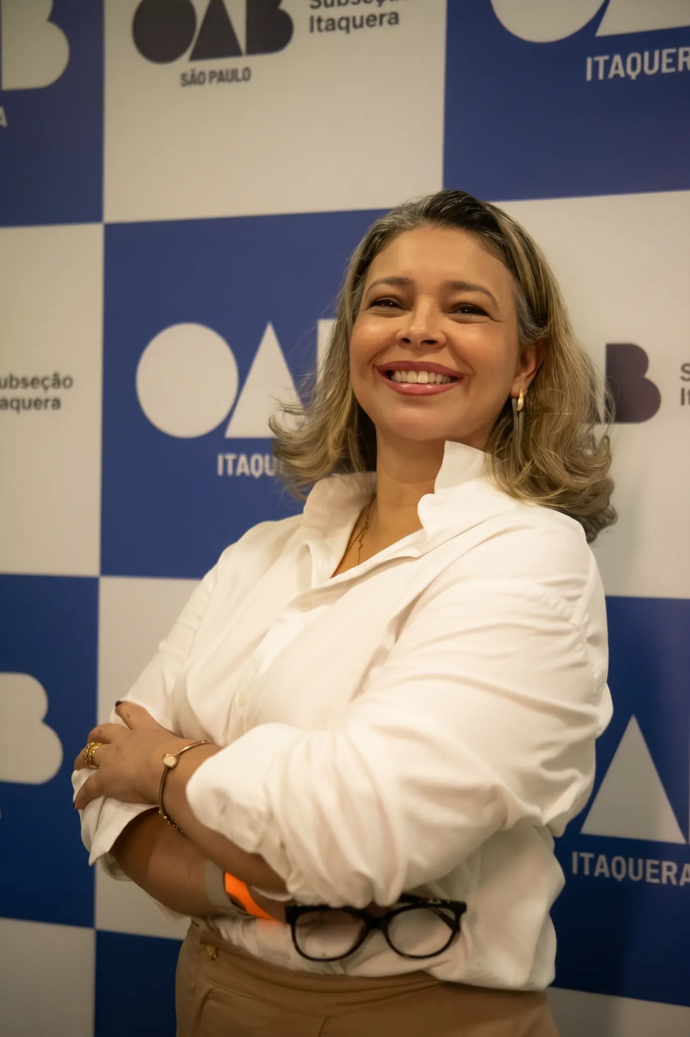 Representante da Justiça Inclusiva sorrindo, usando camisa branca